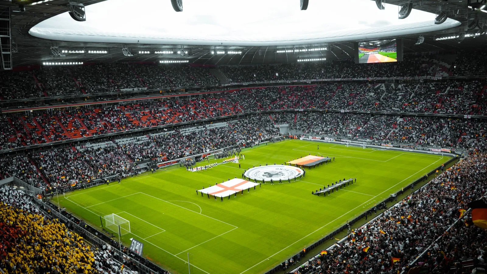 A vibrant soccer stadium filled with fans watching a game, flags displayed on the field.