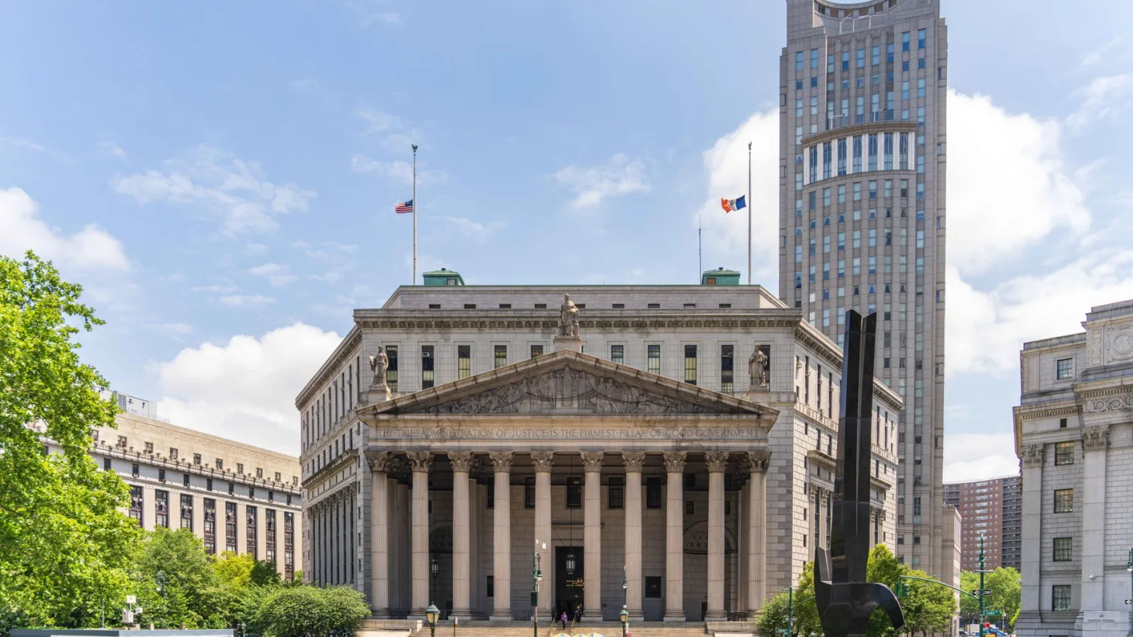 View of the historic New York County Courthouse with clear skies and cityscape.