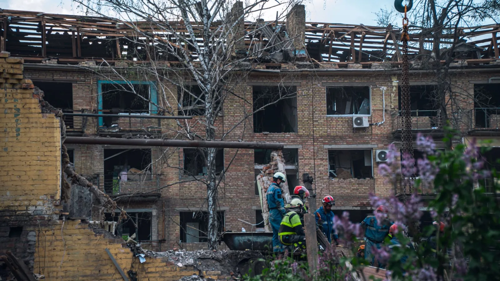 Firefighters in Kyiv inspect a damaged building after an attack, highlighting the devastation of war.